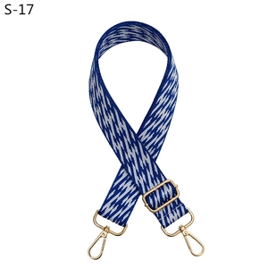 Detail view of blue and white geometric woven replacement shoulder strap with gold metal buckles
