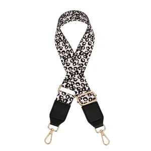 Detail of adjustable leopard print bag strap with black leather ends and golden metal hooks
