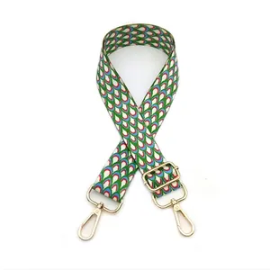 Detail of colorful geometric pattern strap with gold rotating metal hooks and buckles