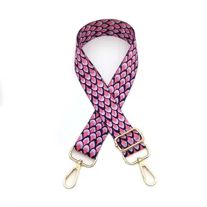 Close-up of adjustable colorful peacock pattern bag strap with gold metal hooks