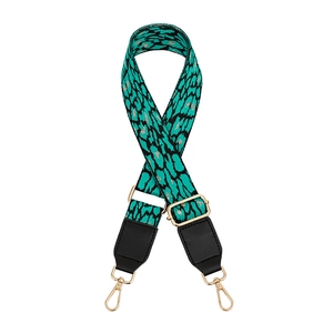 Detail of leopard print purse strap with gold thread weaving and black leather ends