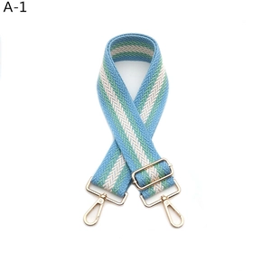 Detail of adjustable woven shoulder strap with blue and green chevron pattern and gold hardware