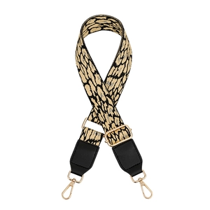 Close-up of adjustable leopard print bag strap with golden buckles and black leather ends