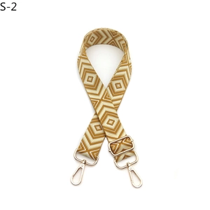 Close-up of diamond pattern woven bag strap with golden lobster clasps and buckle
