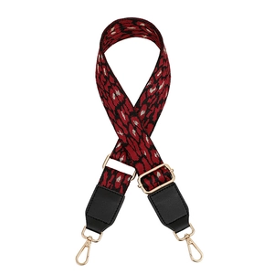 Detail of leopard print bag strap with gold metal buckles and black leather ends