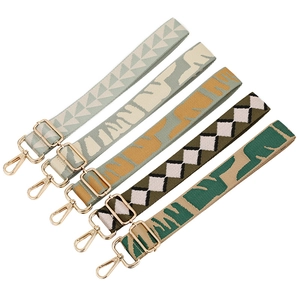 Detail of adjustable jacquard bag straps with gold metal hooks and geometric patterns