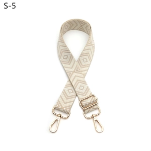 Detail of adjustable guitar-style strap with beige diamond pattern and gold hardware