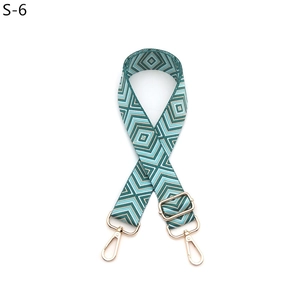 Detail view of adjustable woven geometric guitar strap with gold metal lobster clasps