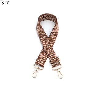 Detail of adjustable geometric diamond pattern bag strap with gold metal buckles