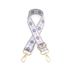 Close-up of snowflake pattern embroidery on adjustable bag strap with gold metal hooks