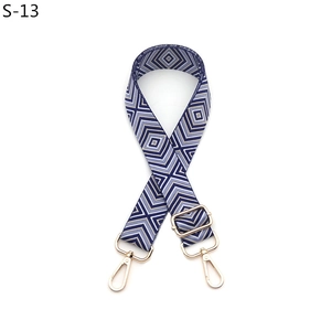 Detail of adjustable geometric diamond pattern bag strap with gold lobster clasps