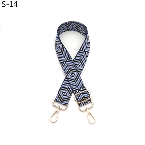 Detail of adjustable geometric diamond pattern shoulder strap with gold metal lobster clasps
