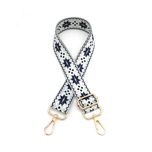 Detail of geometric star pattern strap with gold metal lobster clasps and buckles
