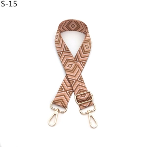 Close-up of geometric diamond pattern shoulder strap with golden metal swivel hooks