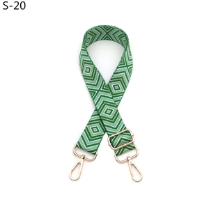 Close-up of green and white diamond geometric woven strap with gold metal buckles
