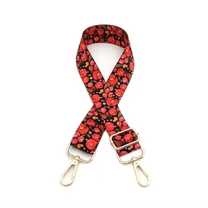 Detail view of floral replacement bag strap with golden metal carabiner hooks
