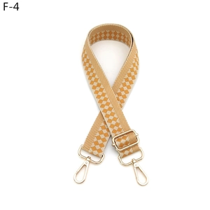 Detail of adjustable checkered bag strap in yellow and beige with gold hardware
