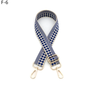 Detail view of woven checkered shoulder strap with gold metal lobster clasps and sliders