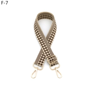 Detail of adjustable woven strap with brown checkerboard pattern and gold lobster claws