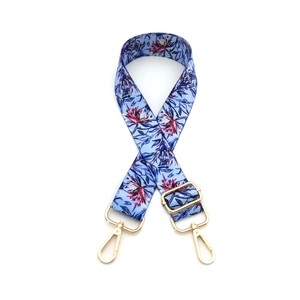 Adjustable floral print crossbody bag strap with light blue base and gold metal hooks