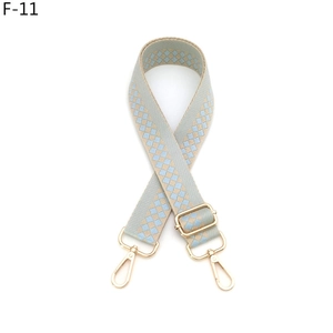 Detailed view of adjustable light blue checkered canvas strap with gold swivel hooks