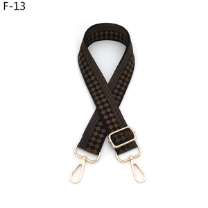 Detail of adjustable checkered wide shoulder strap with golden metal lobster clasps