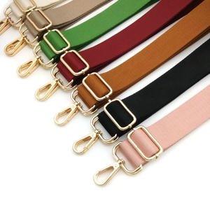 Detail of adjustable thick crossbody bag straps with polished gold metal swivel hooks