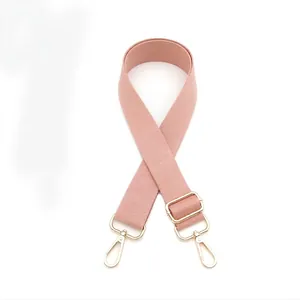Close-up of pink adjustable bag strap with golden metal spring hooks and buckle