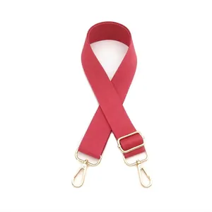 Detail view of adjustable dark red thickened nylon bag strap with light gold metal swivel hooks