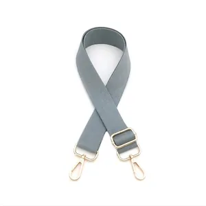 Detail of adjustable gray-blue nylon bag strap with polished light gold metal lobster clasps