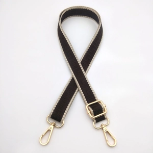 Close-up of 2.5cm wide adjustable bag strap with gold metal buckles and greek pattern