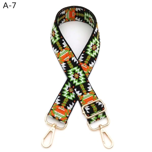 Detail view of colorful jacquard guitar style purse strap with gold lobster clasps