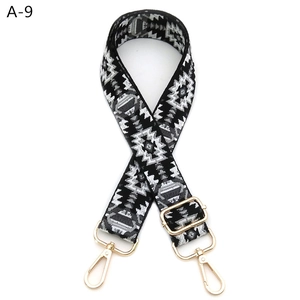Detailed view of adjustable woven bag strap with geometric patterns and gold metal hooks