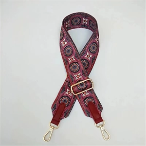 Detail of red and blue geometric pattern bag strap with gold metal buckles