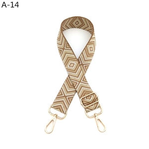 Detailansicht eines gewebten Taschenriemens mit geometrischem Muster und Goldkarabiner