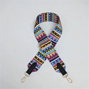 Detail of adjustable geometric ethnic pattern wide strap with gold metal swivel hooks