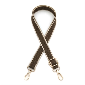 Detail of woven bag strap with geometric patterns and gold metal lobster clasps