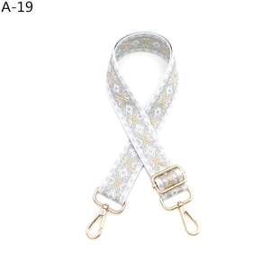 Detail eines verstellbaren Taschengurt mit champagnergoldenem Jacquard und Metallhaken