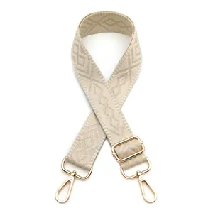 Detail of adjustable geometric diamond pattern bag strap with gold metal lobster clasps