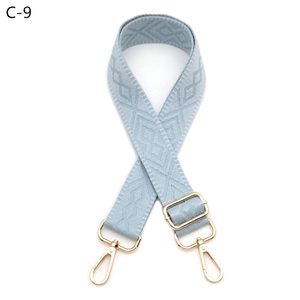 Detail of adjustable blue-grey diamond pattern bag strap with gold lobster clasps