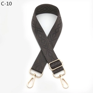 Detail of dark grey geometric diamond woven bag strap with adjustable gold hardware