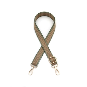 Detail of adjustable geometric jacquard bag strap with gold metal hooks and buckle