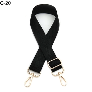 Detail of black diamond pattern jacquard bag strap with gold metal lobster clasps