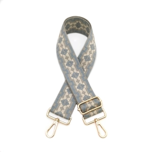Close-up of geometric diamond weave bag strap with golden metal lobster clasps