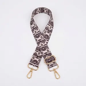 Close-up of geometric woven shoulder strap with gold metal lobster clasps and buckle