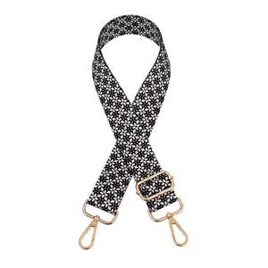 Close-up of black and white geometric patterned woven shoulder strap with gold hardware
