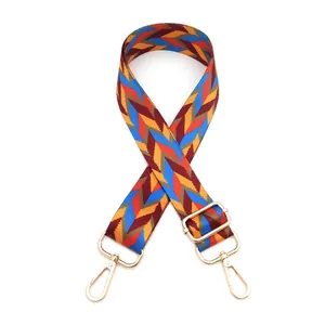 Detail of bohemian woven bag strap with golden rotating hooks and colorful zigzag pattern