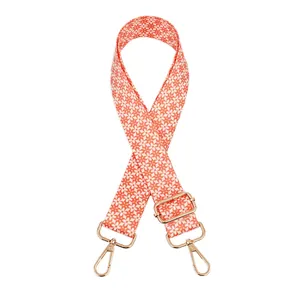 Detail of adjustable orange floral woven strap with golden swivel metal hooks
