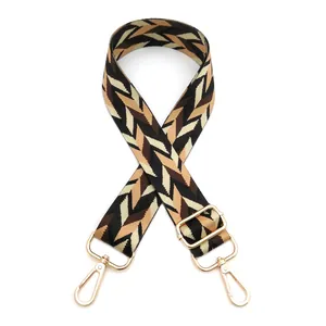 Close-up of ethnic style woven bag strap with golden lobster clasp and chevron pattern