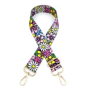 Detail of adjustable floral replacement strap with colorful daisy pattern and gold hooks